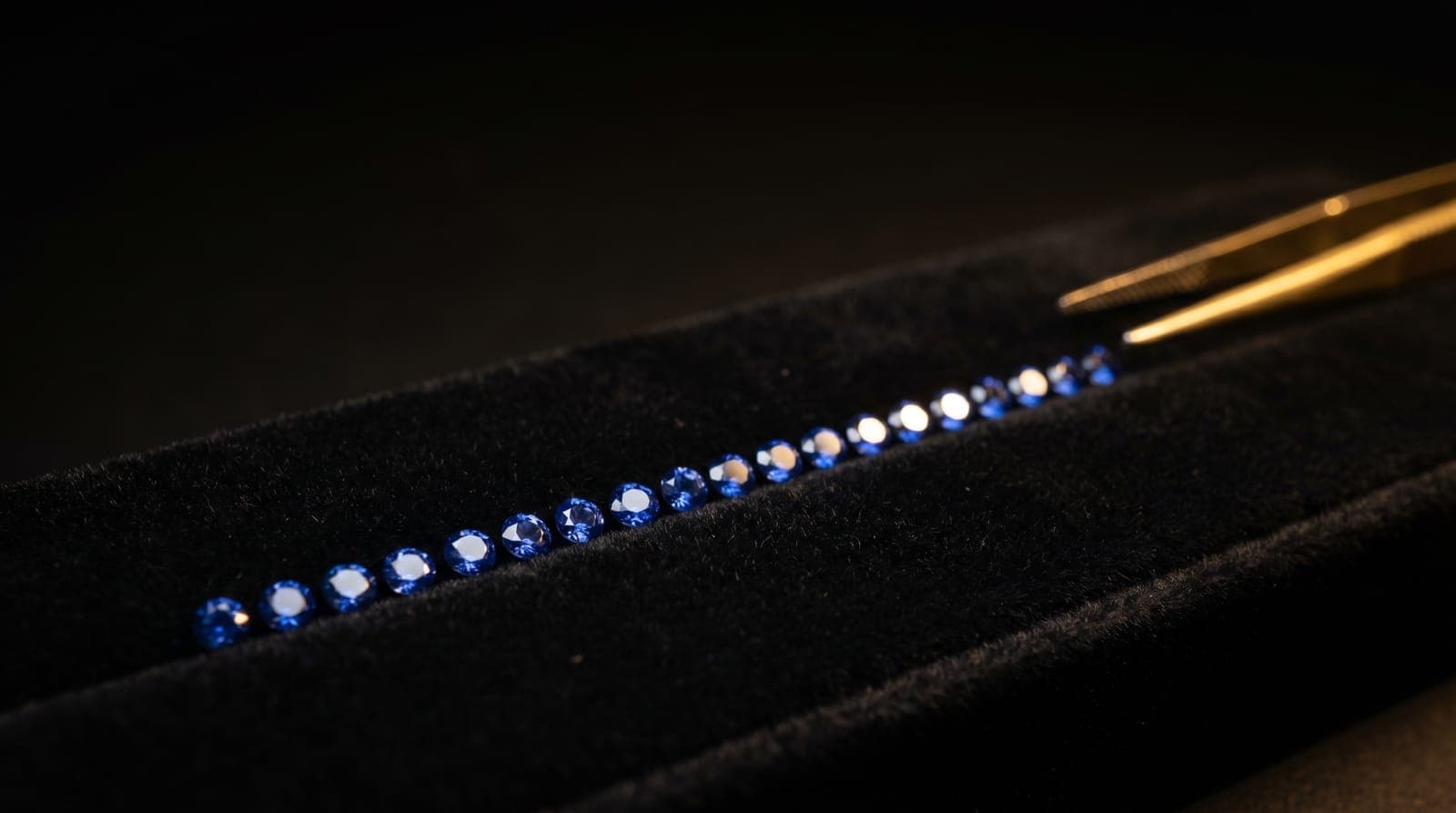 Calibrated small-size sapphires sorted by color and millimeter tolerance for pavé setting work