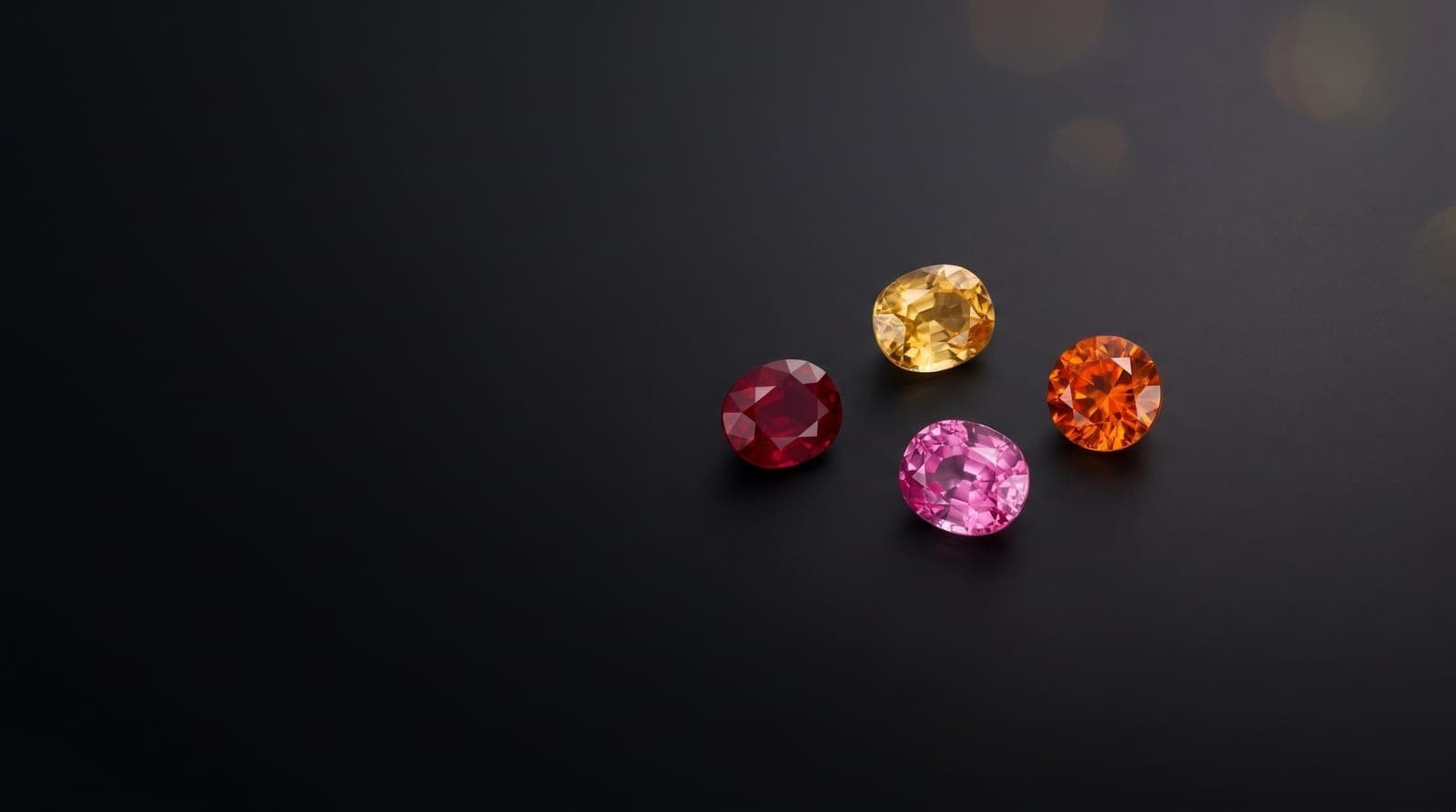 Assorted colored gemstones arranged next to jewelry design sketches