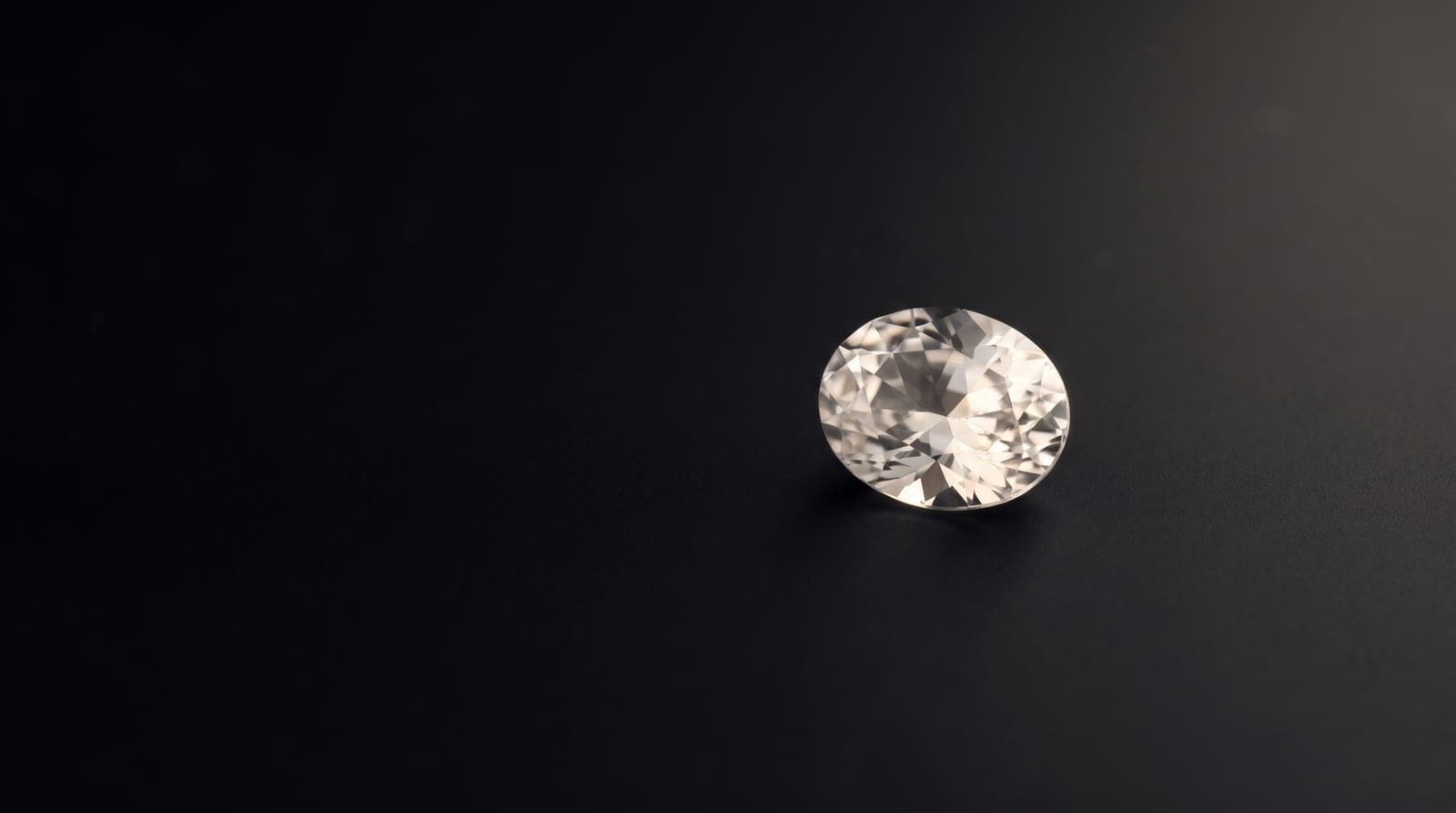 Side-by-side comparison of a machine-cut and hand-cut gemstone on a workbench